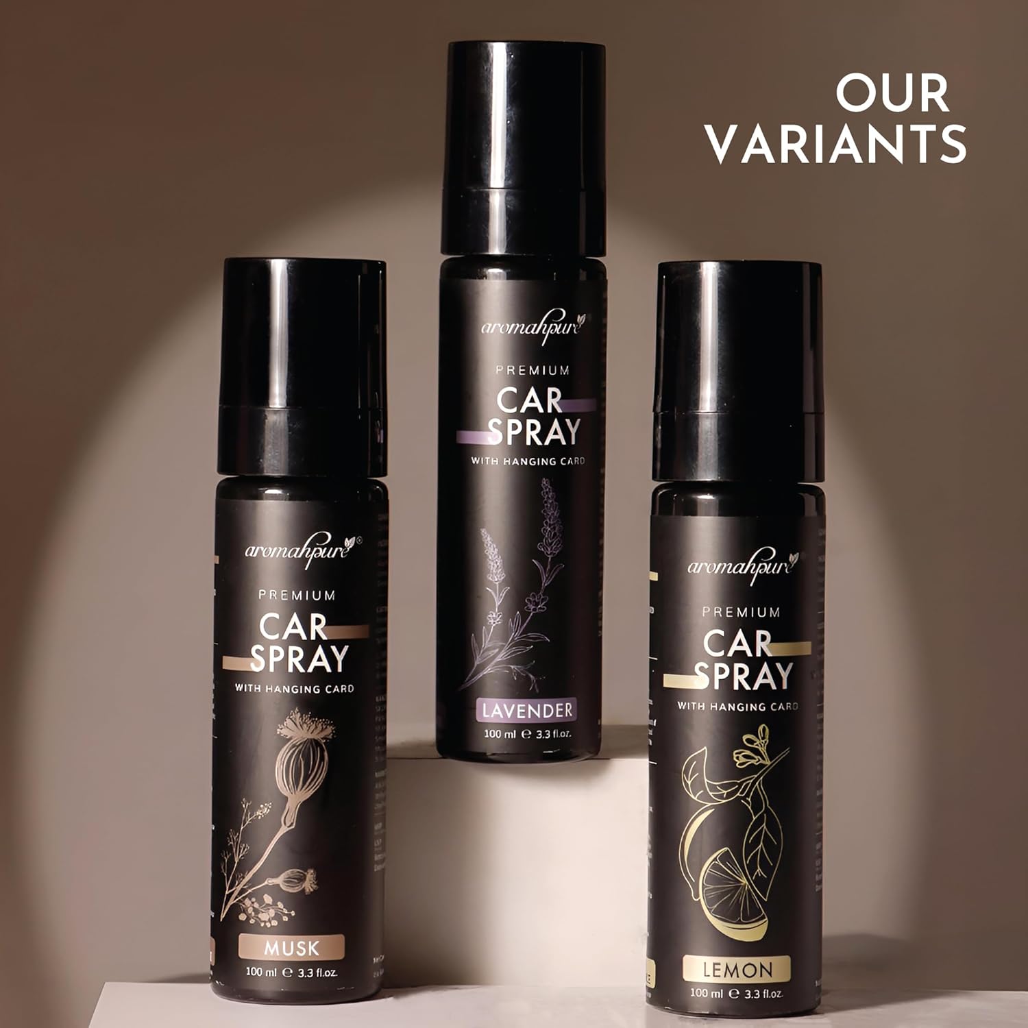 Four black car spray bottles with different scents on a neutral background
