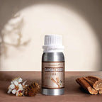 Sandalwood aroma oil bottle with sandalwood pieces and flowers on a wooden surface