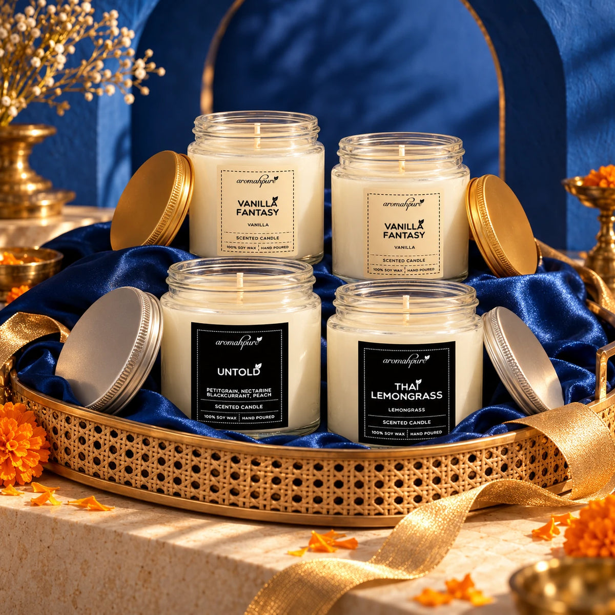 Four Aromahpure Silver and Golden Screw Jar candles styled in a festive blue silk and gold hamper